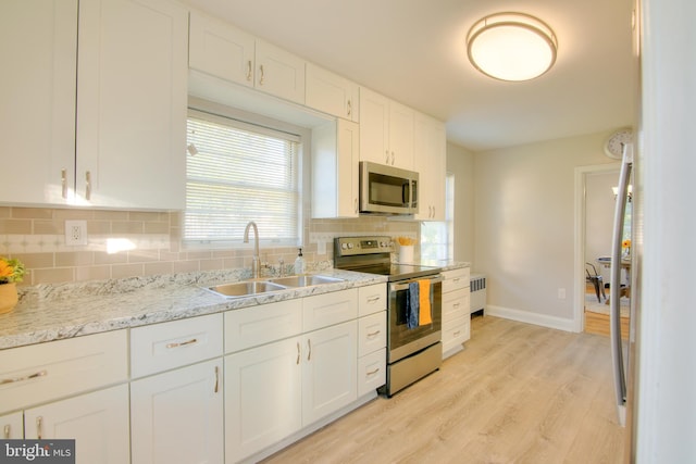 kitchen with light hardwood / wood-style flooring, stainless steel appliances, sink, and white cabinetry