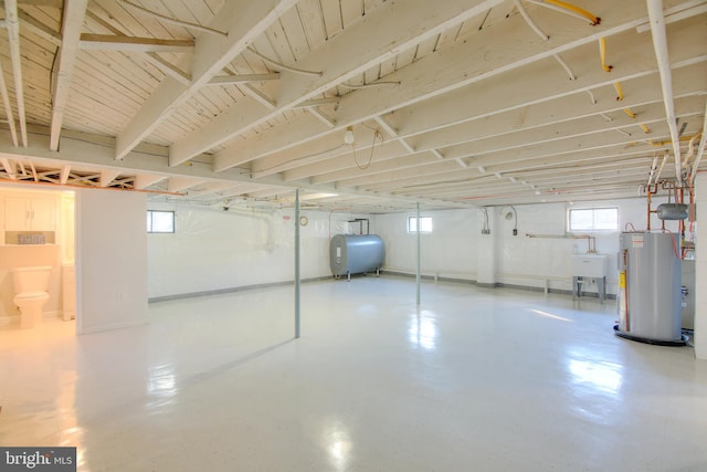 basement featuring gas water heater and sink