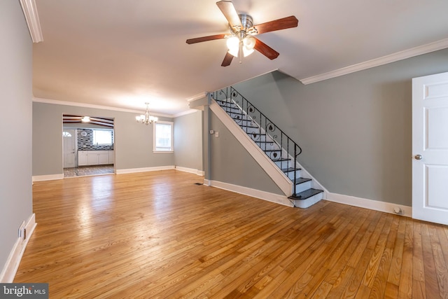 unfurnished living room featuring light wood-type flooring, crown molding, and ceiling fan with notable chandelier