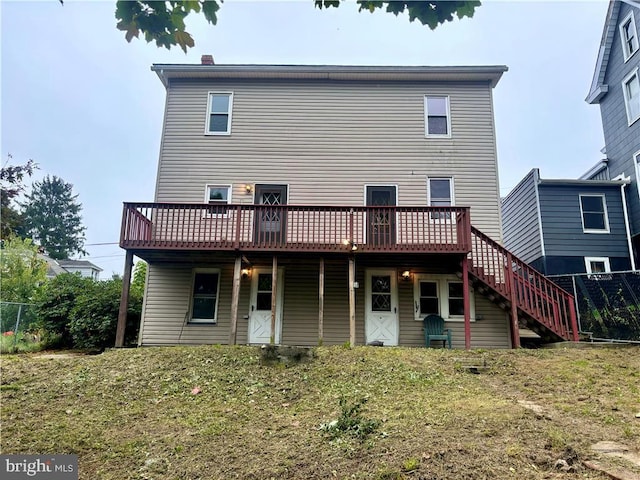 rear view of house featuring a yard and a deck