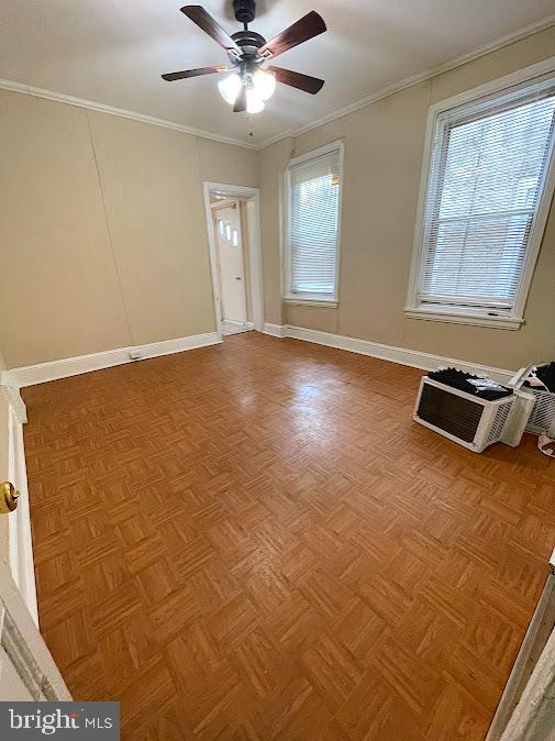 unfurnished room featuring light parquet flooring, ornamental molding, and ceiling fan