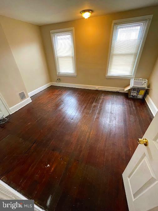 spare room featuring dark wood-type flooring and a wealth of natural light