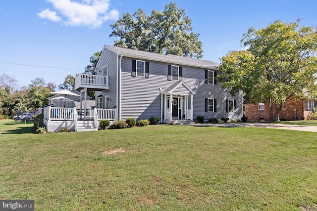 view of front of house with a wooden deck and a front lawn