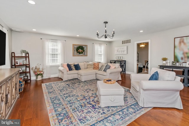 living room with dark hardwood / wood-style floors and a chandelier