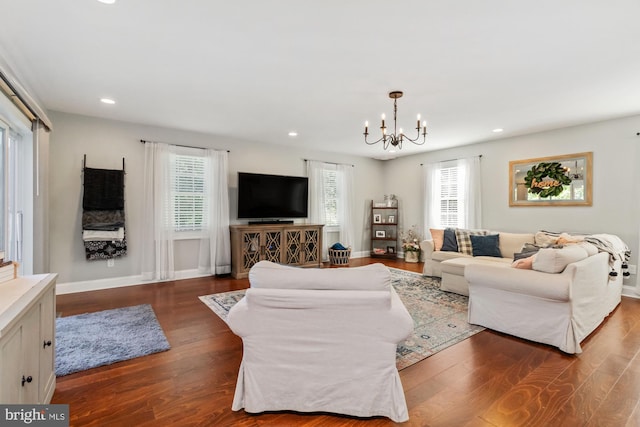 living room featuring dark hardwood / wood-style floors and an inviting chandelier