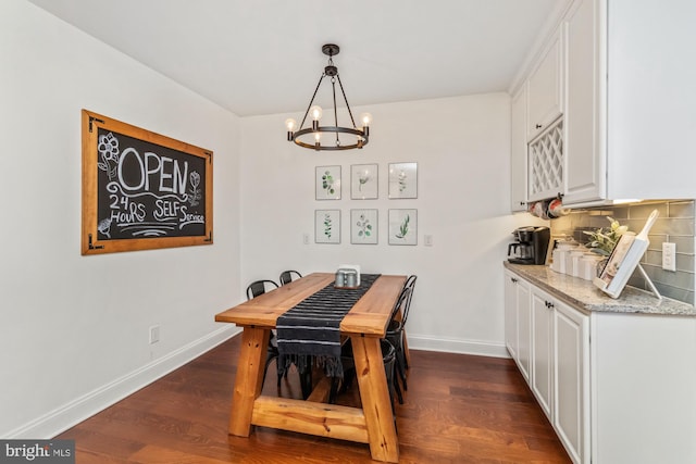 dining room featuring dark wood-type flooring and a chandelier