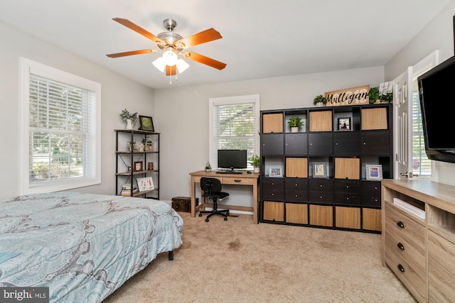 bedroom featuring multiple windows, light colored carpet, and ceiling fan