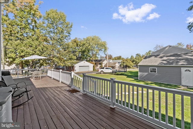 wooden deck featuring an outdoor structure, a yard, and a garage