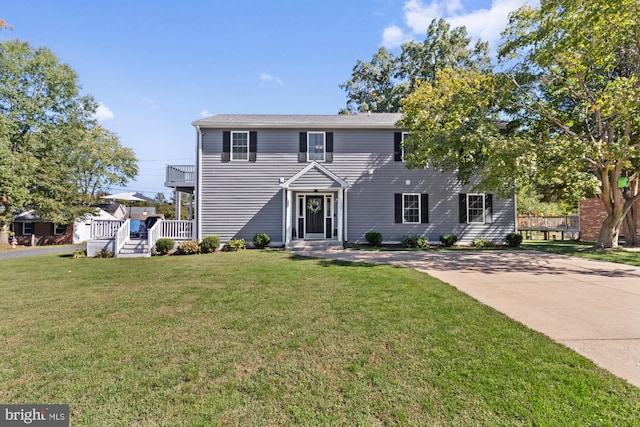 view of front of property with a balcony and a front lawn