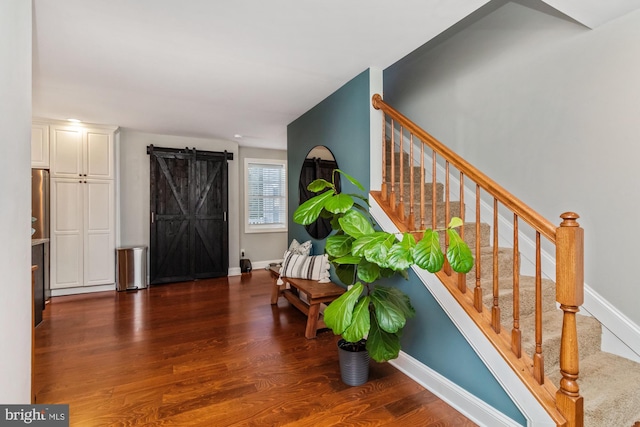 entryway with a barn door and dark hardwood / wood-style floors