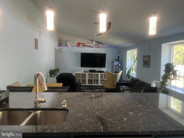 kitchen with decorative light fixtures, sink, and vaulted ceiling