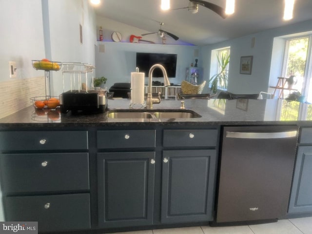 kitchen with ceiling fan, sink, vaulted ceiling, light tile patterned floors, and dishwasher