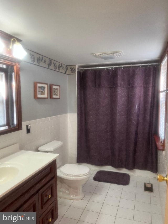 bathroom featuring vanity, tile walls, toilet, and tile patterned floors