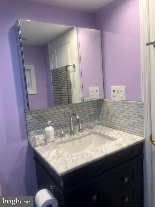 bathroom featuring vanity and backsplash