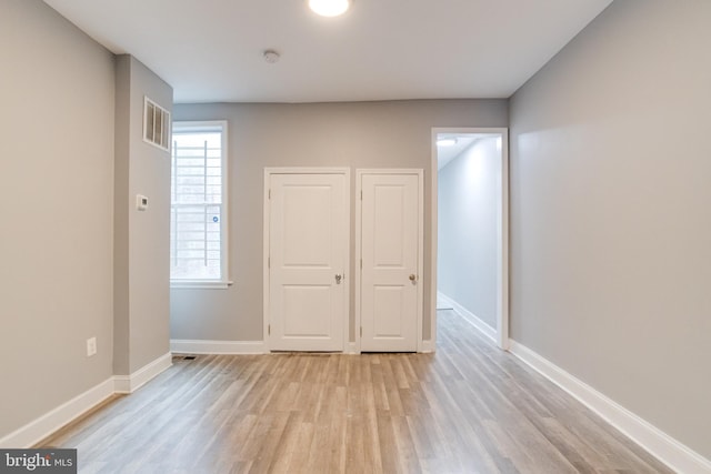 unfurnished bedroom with light wood-type flooring