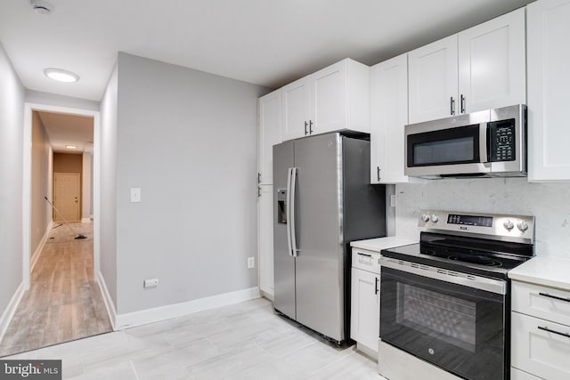 kitchen featuring appliances with stainless steel finishes, light hardwood / wood-style flooring, and white cabinets