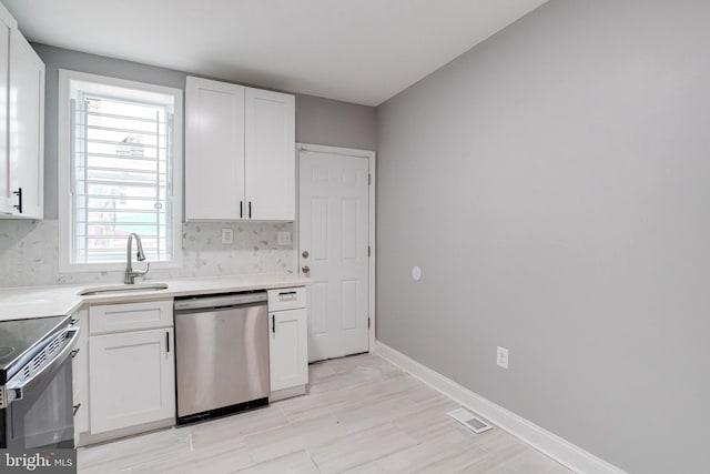 kitchen with stainless steel appliances, white cabinets, a healthy amount of sunlight, and sink