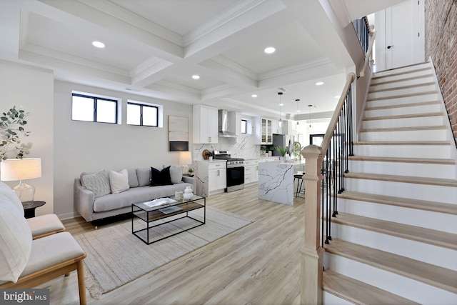 living room featuring coffered ceiling, beamed ceiling, light wood-type flooring, and ornamental molding