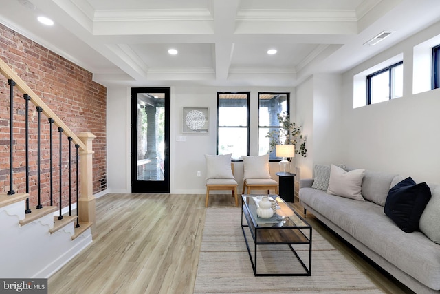 living room featuring light hardwood / wood-style flooring, ornamental molding, and a healthy amount of sunlight