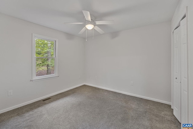 carpeted empty room featuring ceiling fan