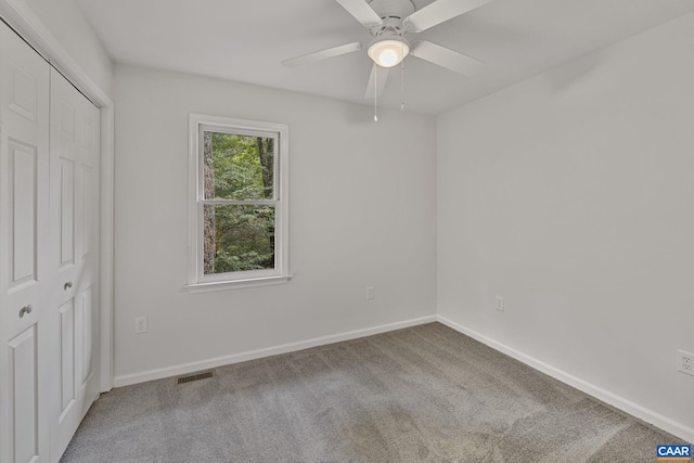 unfurnished bedroom with ceiling fan, a closet, and carpet flooring