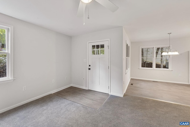 entrance foyer with ceiling fan with notable chandelier and hardwood / wood-style floors