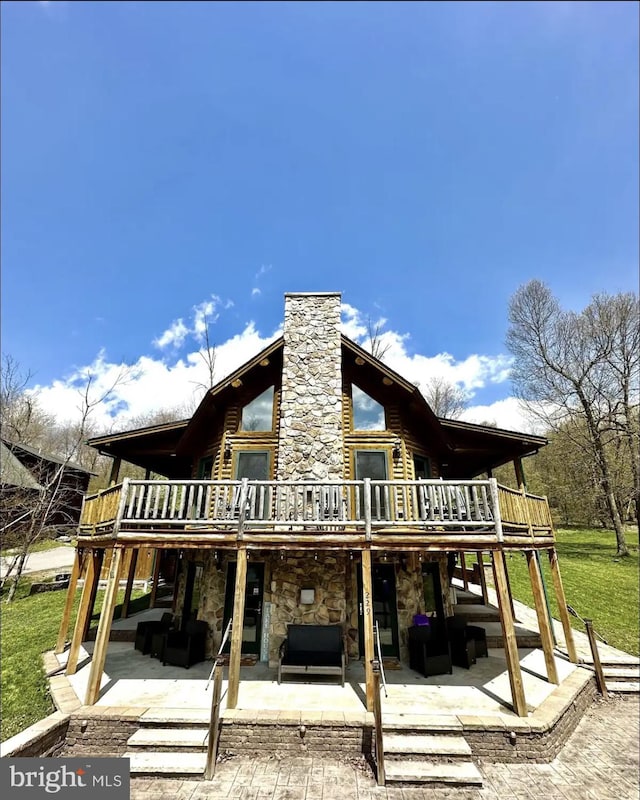 back of house featuring a patio, a lawn, and a wooden deck