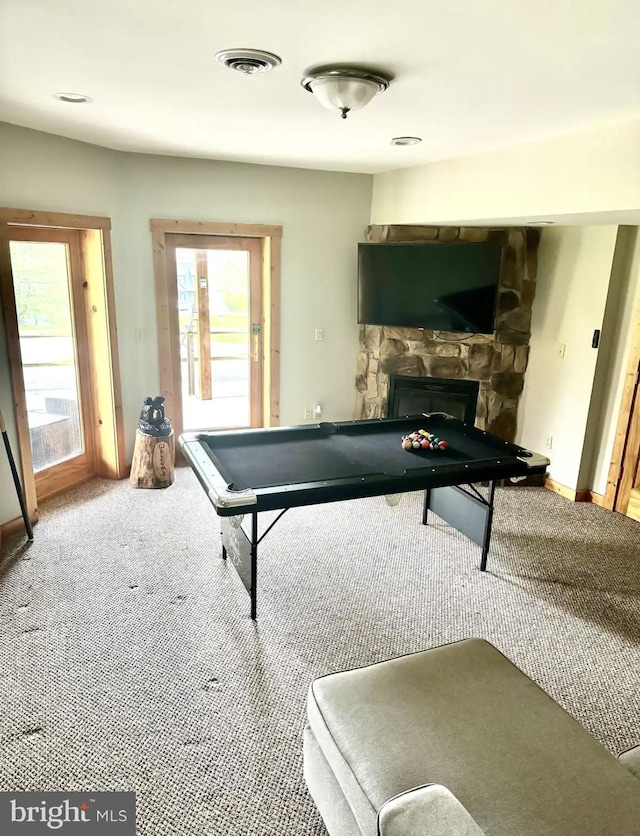 rec room featuring carpet flooring and a stone fireplace