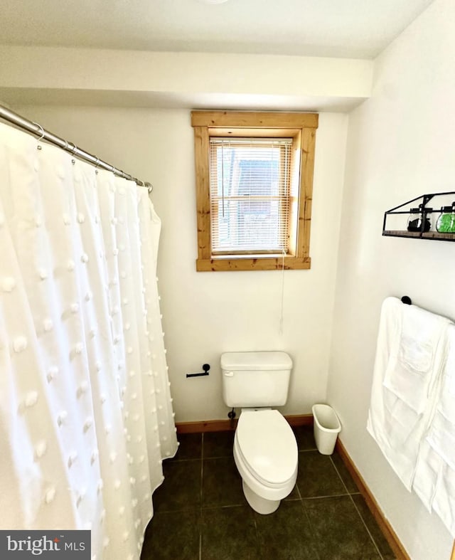 bathroom featuring a shower with shower curtain, tile patterned flooring, and toilet