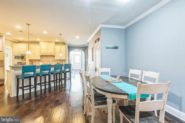 dining room with crown molding and dark hardwood / wood-style flooring