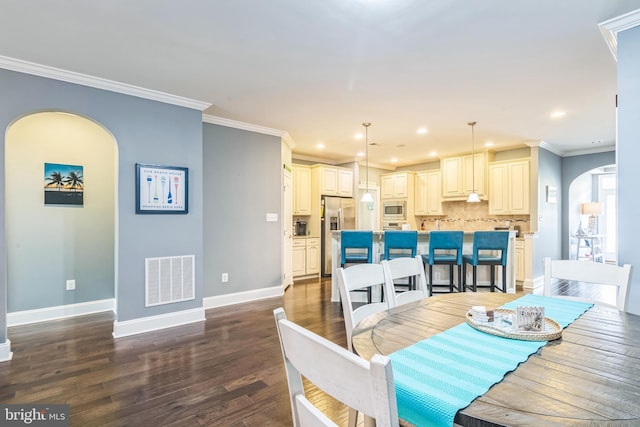 dining room with crown molding and dark wood-type flooring