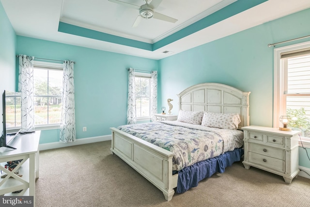 carpeted bedroom featuring ornamental molding, ceiling fan, and a raised ceiling