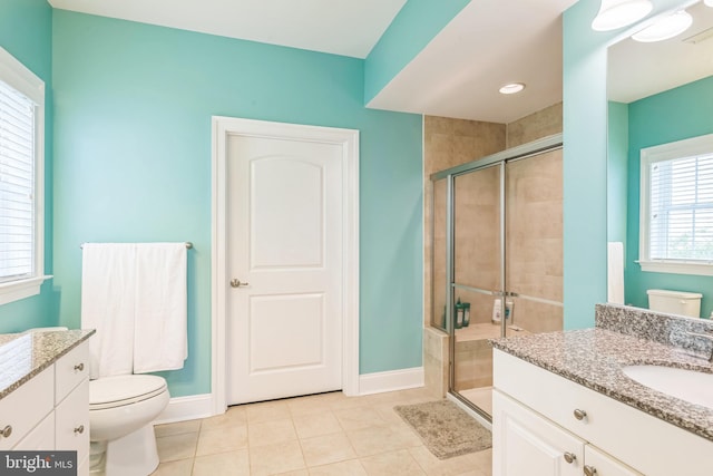 bathroom with tile patterned flooring, a shower with door, vanity, and toilet