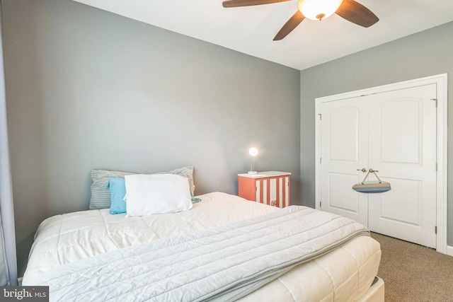 carpeted bedroom with ceiling fan and a closet