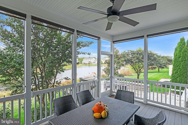 sunroom / solarium featuring ceiling fan, a water view, and a healthy amount of sunlight