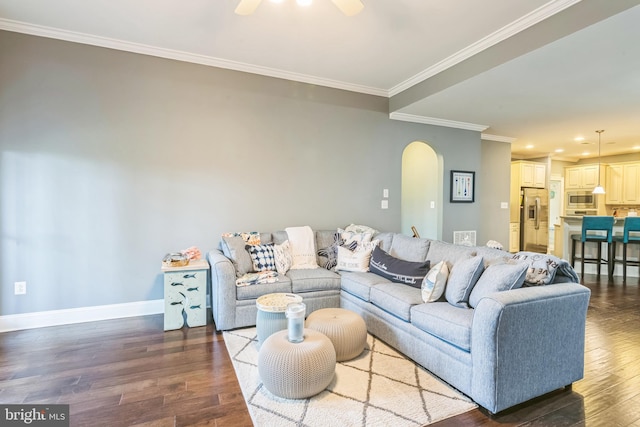 living room with ceiling fan, crown molding, and dark wood-type flooring