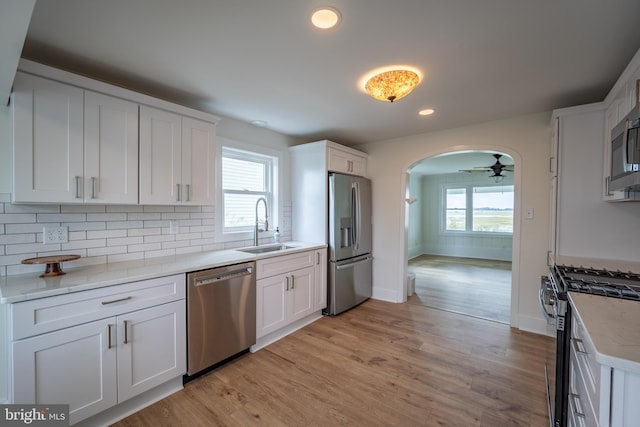 kitchen with ceiling fan, appliances with stainless steel finishes, white cabinetry, and a healthy amount of sunlight