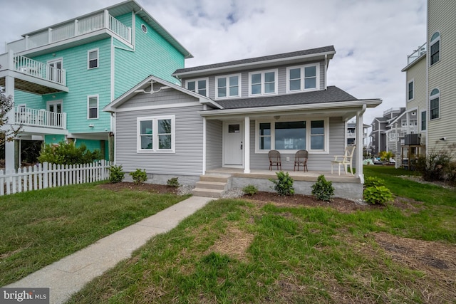 view of front of property with a balcony, a porch, and a front yard