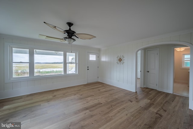 interior space with ceiling fan, light wood-type flooring, and ornamental molding