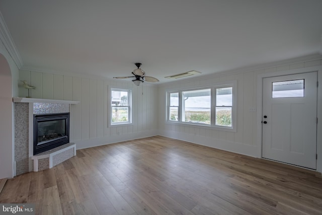 unfurnished living room with ceiling fan, light hardwood / wood-style flooring, and ornamental molding