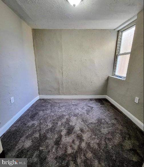 carpeted empty room with a textured ceiling