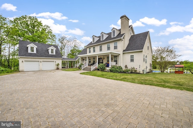 cape cod-style house featuring a garage, a front lawn, and covered porch