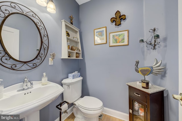 bathroom with sink, hardwood / wood-style floors, and toilet