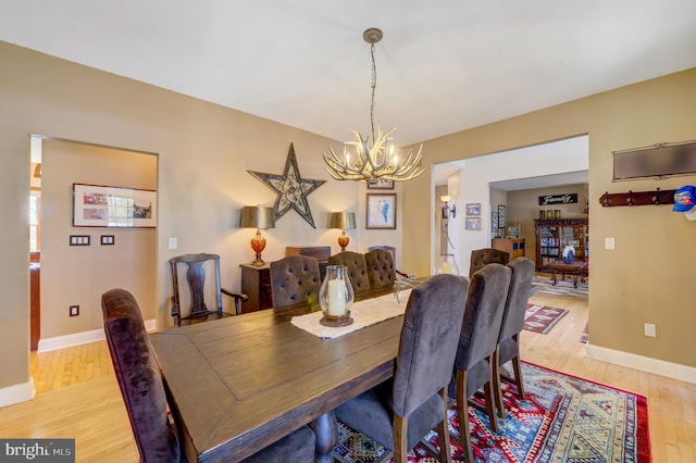 dining space featuring light hardwood / wood-style flooring and a notable chandelier