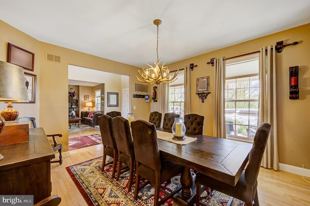 dining area with an inviting chandelier and light wood-type flooring