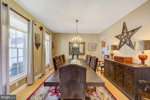 dining area with a notable chandelier and light wood-type flooring