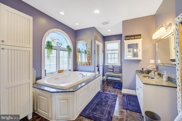 bathroom featuring vanity and a bath