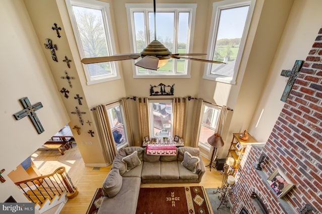 interior space featuring a towering ceiling, ceiling fan, and light hardwood / wood-style flooring