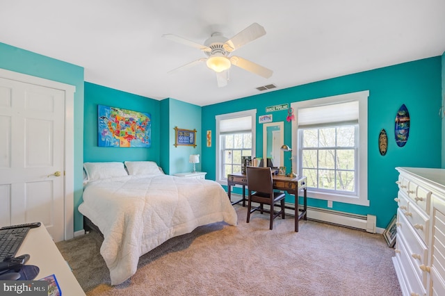 carpeted bedroom with ceiling fan and a baseboard heating unit