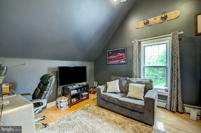 office space with lofted ceiling, baseboard heating, and light hardwood / wood-style flooring